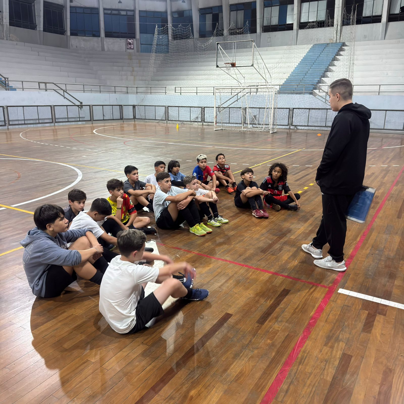 Crianças reunidas em roda na quadra da FEG